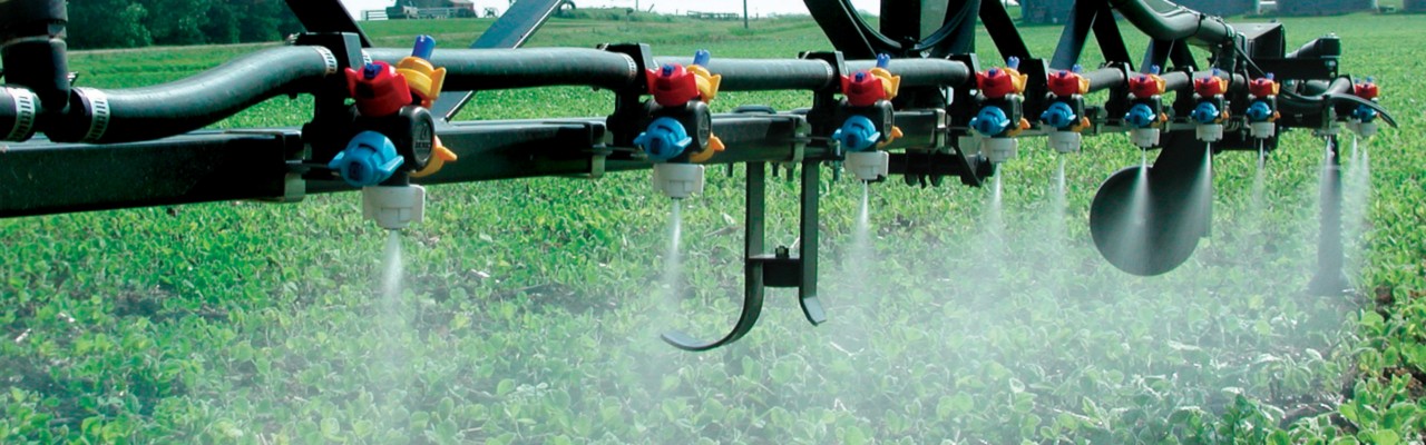 Multi-color Hypro spray nozzles spraying crops.