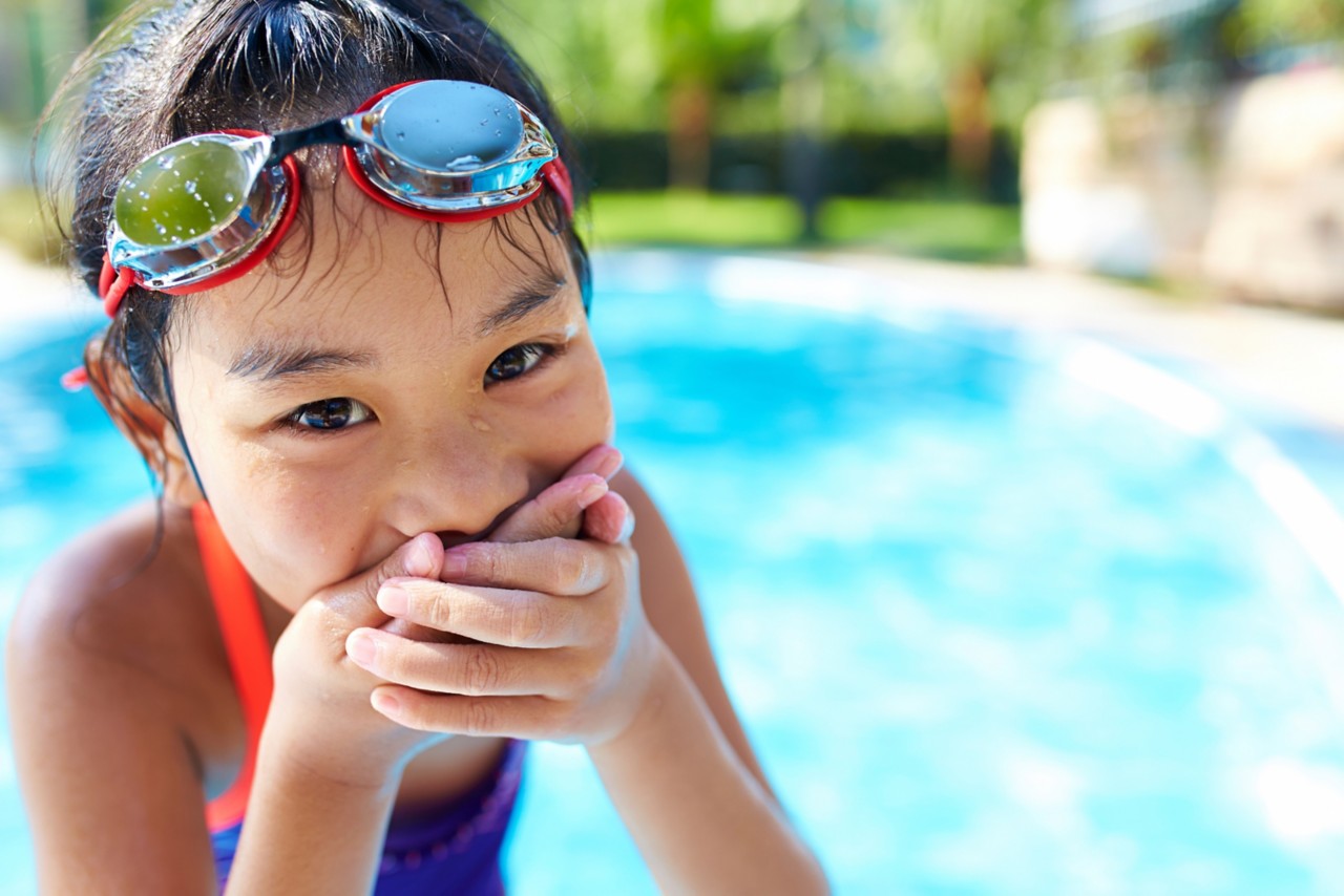 close up of one lovely little asian girl smile at camera in the swimming pool