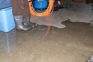 A pair of gray boots standing in a flooded basement; Adobe Stock: 283056291