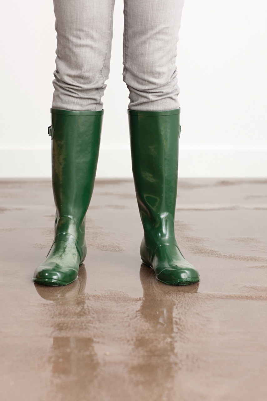 Green rain boots standing on flooded brown carpet; Gettyimages: 107908200
